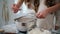 Mother daughter hands sifting flour home closeup. Unknown family cooking pastry