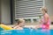 Mother and daughter have fun at pool side in tropical beach resort