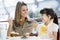 Mother and daughter having cake at cafe