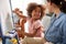 Mother And Daughter Having Fun Drawing Picture On Whiteboard At Home Together