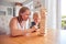 Mother And Daughter Having Fun Sitting At Table Playing Game Building Tower From Wooden Blocks