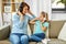 Mother and daughter in headphones listen to music