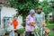 mother and daughter in headscarves spraying flower plants