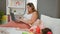 Mother and daughter in a heartfelt moment, playing with hoops while sitting on the bed in their cozy bedroom, remote work in the