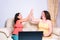 Mother and daughter high-five after successfully completing an online purchase