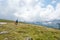 Mother and daughter hiking green alpine pastures.