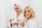 Mother and daughter holding containers with cosmetic cream