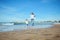 Mother and daughter holding hands, running barefoot on the wet sand, leaving footsteps, enjoying happy moments together