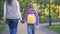 Mother and daughter holding hands and walking to additional classes, schoolgirl