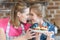 Mother and daughter holding homemade cupcakes with strawberries