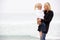 Mother And Daughter On Holiday Standing On Beach