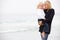 Mother And Daughter On Holiday Standing On Beach