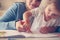 Mother and daughter at home. Mother teaching her daughter to drawing and writing.