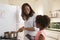 Mother And Daughter At Home Preparing Meal In Kitchen