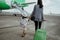 A mother and daughter join hands walking with a suitcase