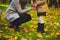 Mother and daughter keep bottle filled autumn treasures with empty label