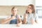 Mother with daughter in kitchen eating ice cream. Good relations of parent and child. Happy family concept