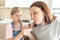 Mother with daughter in kitchen eating ice cream. Good relations of parent and child. Happy family concept