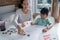 Mother and daughter learning to read and write letter at home