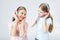 Mother and daughter listening music with headphones in studio