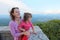 Mother and daughter look on mountain from balcony