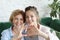 Mother and daughter love. Adult woman and young woman stacking hands in heart sign looking at camera.
