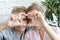 Mother and daughter love. Adult woman and young woman stacking hands in heart sign looking at camera.