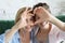 Mother and daughter love. Adult woman and young woman stacking hands in heart sign looking at camera.