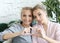 Mother and daughter love. Adult woman and young woman stacking hands in heart sign looking at camera.