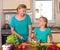 Mother and daughter making fresh vegetable salad. Healthy domestic food concept. Mother and daughter cooking together, help child