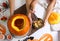 Mother and daughter making pumpkin jack o`lantern at white wooden table, top view. Halloween