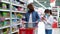 Mother and daughter in masks shopping at grocery store