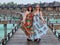 mother and daughter in matching tropical dresses standing together on wooden bridge pathway, women on vacations