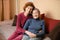 Mother and daughter, mature woman with red hair and elderly old cute happy lady woman with gray hair and deep wrinkles, embrace