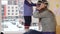 Mother with daughter measure warm winter hats near window. Snowstorm snow fall