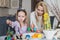 Mother And Daughter Painting Easter Eggs In Home