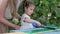 Mother and daughter painting old wood in the garden close up. Home workshop, handicrafts, hand-made concept