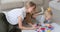 Mother with daughter painting together on paper sheet at home