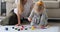 Mother with daughter painting together on paper sheet at home