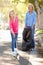 Mother And Daughter Picking Up Litter In Suburban Street