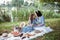 A mother and daughter on a picnic in a park on the banks of a river