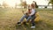 Mother and daughter play on bean bag chair in a summer park on sunset