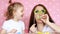 Mother and daughter play together, laugh and dress glasses and blowing horns. The concept of a holiday, party, birthday