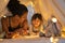 Mother and daughter playing at home in tent