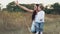 Mother and daughter pointing their fingers at the sky on the autumn field