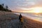 A mother and daughter posing for a photo on agate beach with the waves crashing to shore and the sun setting