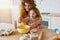 Mother and daughter prepare a cake together in the kitchen