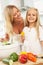 Mother & Daughter Preparing Salad In Kitchen