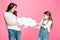Mother and daughter pulling blank speech bubble on pink
