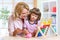 Mother and daughter putting coins into piggy bank